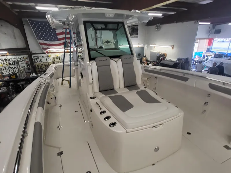 Slide: The Image of 2024 Caymas 34 CT boat interior with seating and American flag in background. - 18