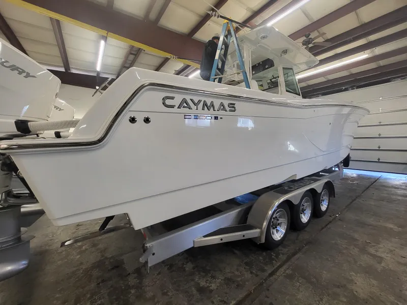 Slide: The Image of 2024 Caymas 34 CT boat on a triple-axle trailer in a warehouse. - 7