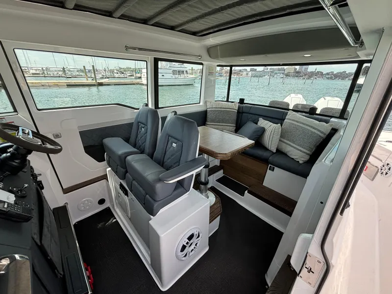 Slide: The Image of Interior of 2020 Axopar 37 XC boat with seating and table, docked at marina. - 12