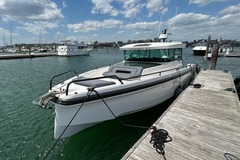 Slide: The Image of 2020 Axopar 37 XC boat docked at a marina on a sunny day. - 5