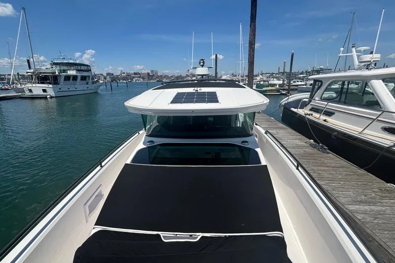 Slide: The Image of 2020 Axopar 37 XC Cross Cabin docked in a marina under clear blue skies. - 37