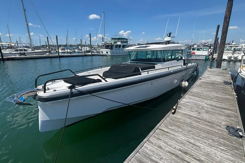 Slide: The Image of 2020 Axopar 37 XC Cross Cabin docked at marina under clear blue sky. - 39