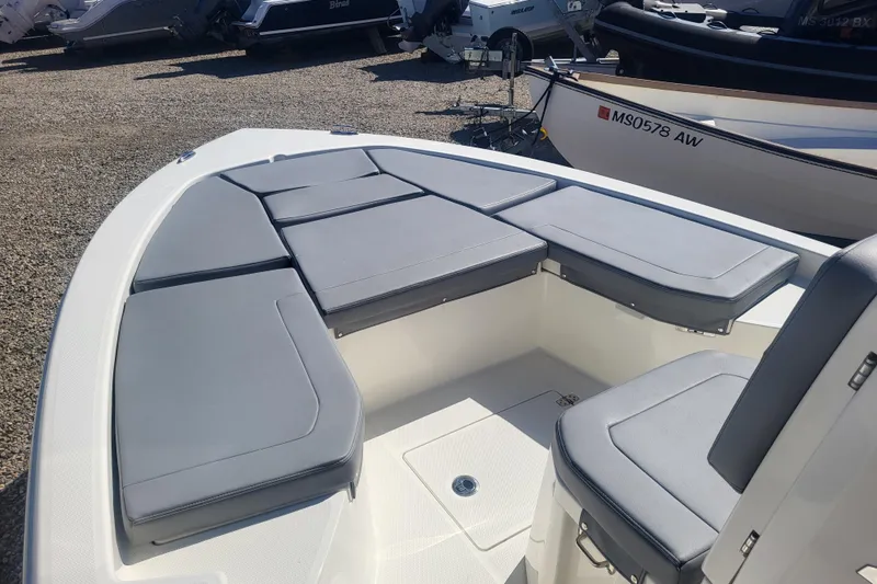 Slide: The Image of 2024 Pathfinder 2200 TRS boat with cushioned seating, displayed outdoors. - 12