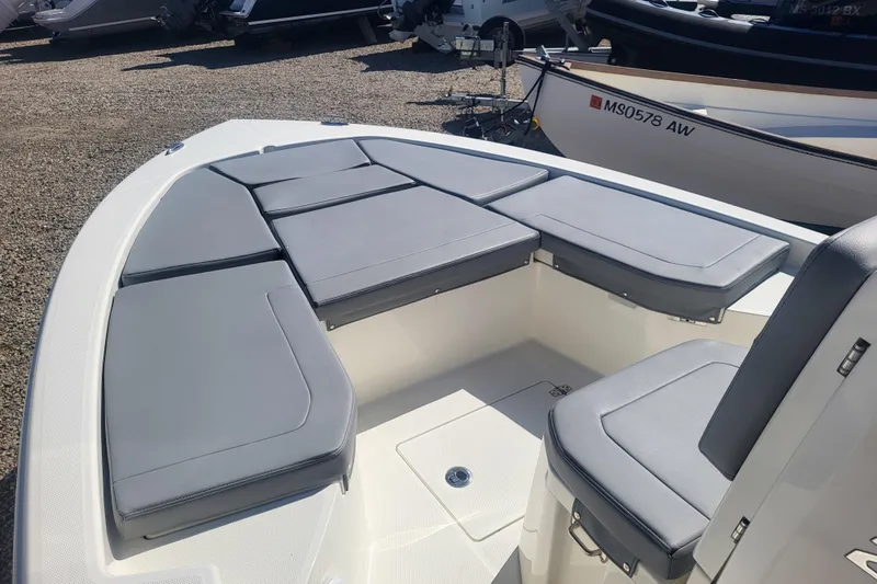 Slide: The Image of 2024 Pathfinder 2200 TRS boat with cushioned seating, displayed outdoors. - 13