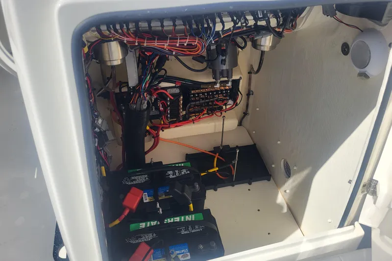Slide: The Image of 2024 Pathfinder 2200 TRS boat electrical compartment with wiring and batteries. - 21