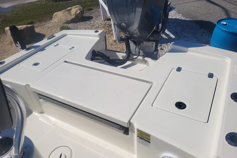 Slide: The Image of 2024 Pathfinder 2200 TRS boat deck with storage compartments and motor. - 27