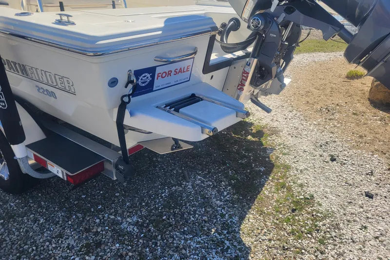 Slide: The Image of 2024 Pathfinder 2200 TRS boat for sale, rear view with motor and trailer. - 3