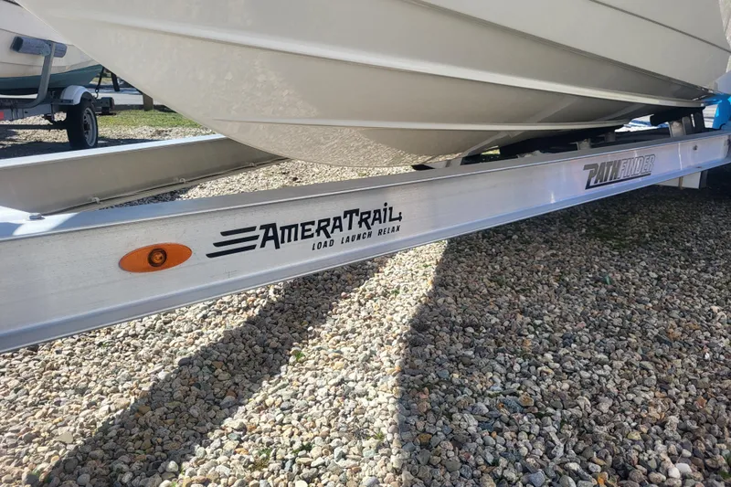Slide: The Image of 2024 Pathfinder 2200 TRS boat on AmeraTrail trailer, parked on gravel. - 4