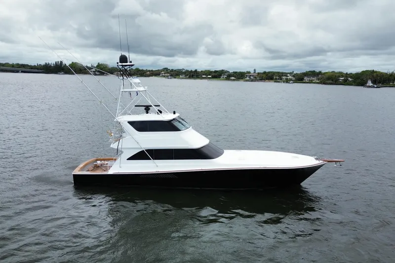 The Image of 2004 Viking 65 Enclosed Bridge yacht with tower on calm water under cloudy sky. - 0