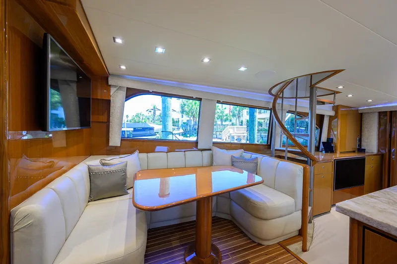 Slide: The Image of Luxurious interior of 2004 Viking 65 Enclosed Bridge yacht with dining area and spiral staircase. - 24