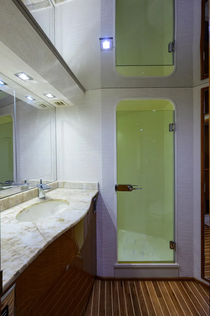 Slide: The Image of 2004 Viking 65 Enclosed Bridge yacht bathroom with marble countertop and glass shower doors. - 35