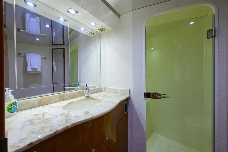 Slide: The Image of Luxurious bathroom in 2004 Viking 65 Enclosed Bridge yacht with marble countertop and glass shower. - 37