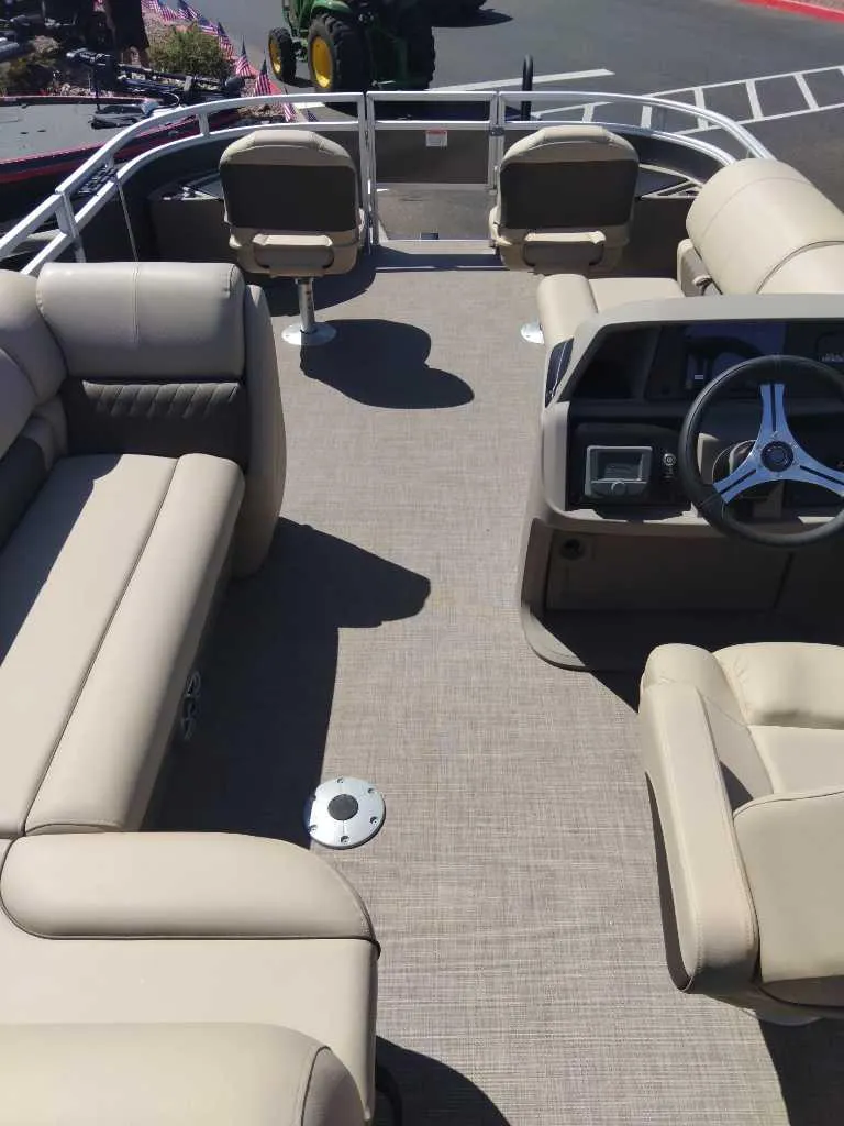 Slide: The Image of 2024 Sun Tracker Fishin' Barge 20 DLX interior with beige seating and steering console. - 3