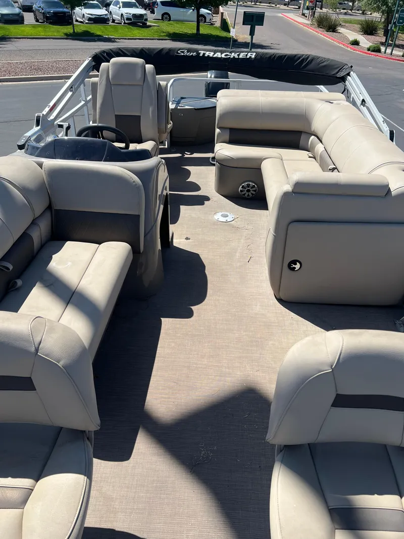 Slide: The Image of 2024 Sun Tracker Fishin' Barge 20 DLX interior with beige seating and spacious layout. - 6