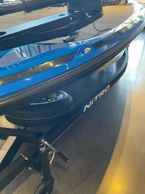 Slide: The Image of 2024 Nitro Z19 boat trailer with spare tire and blue hull. - 1