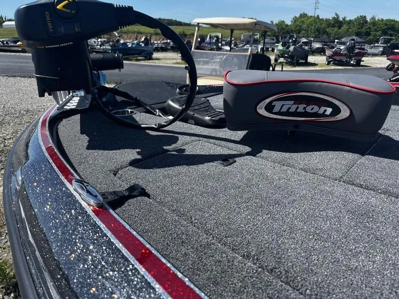 Slide: The Image of 2024 Triton 179 TrX boat deck with equipment in a marina. - 3