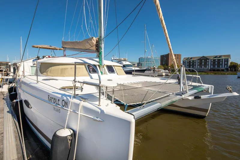 Slide: The Image of 2013 Fountaine Pajot Lipari 41 catamaran docked in a marina under clear blue skies. - 17