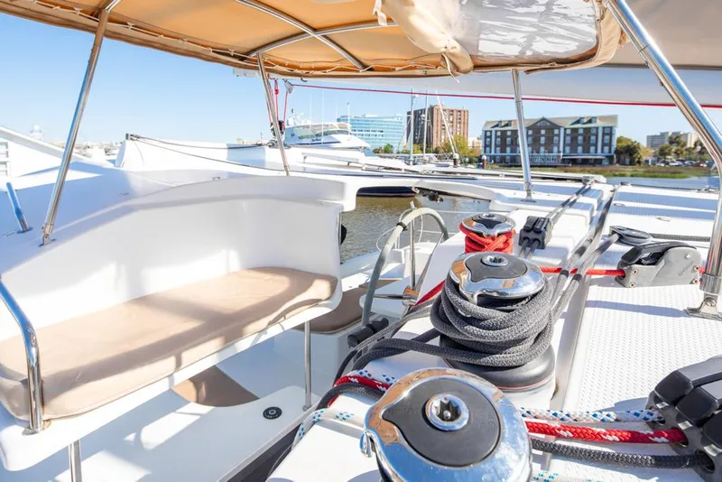 Slide: The Image of 2013 Fountaine Pajot Lipari 41 catamaran deck with seating and winches, docked in a marina. - 24