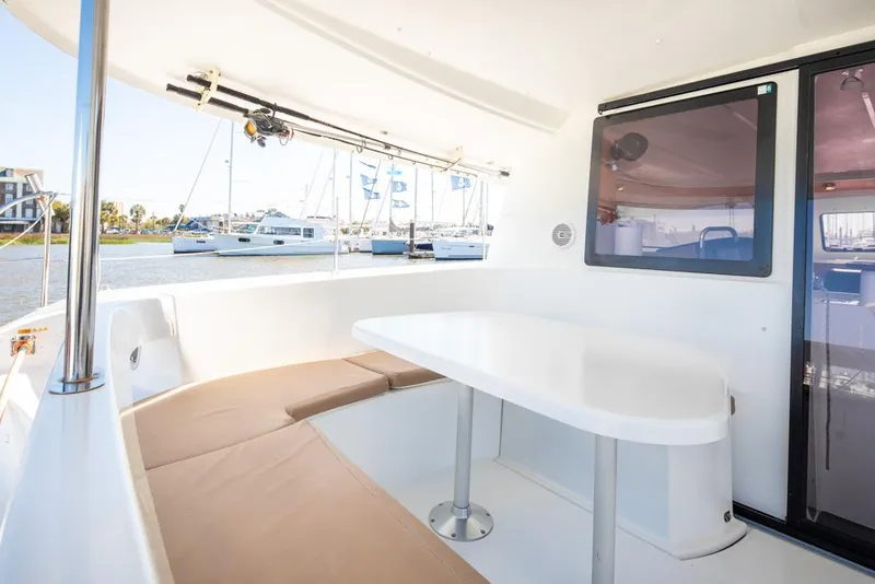Slide: The Image of 2013 Fountaine Pajot Lipari 41 catamaran interior with seating and table, docked at marina. - 32
