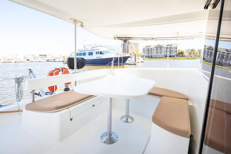 Slide: The Image of 2013 Fountaine Pajot Lipari 41 catamaran, featuring outdoor seating and table, docked at marina. - 33