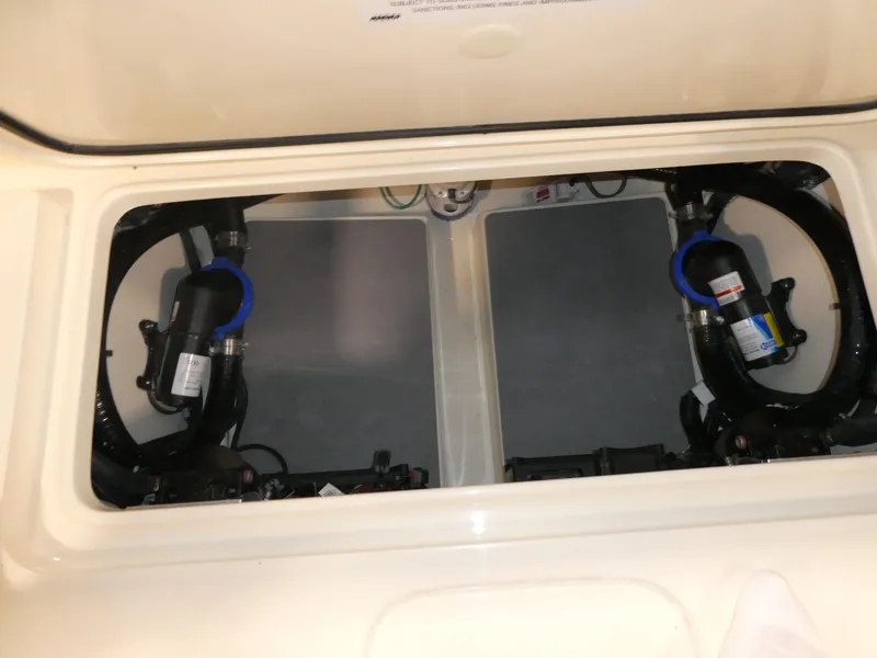 Slide: The Image of 2024 Scout 305 LXF boat storage compartment with visible wiring and components. - 12