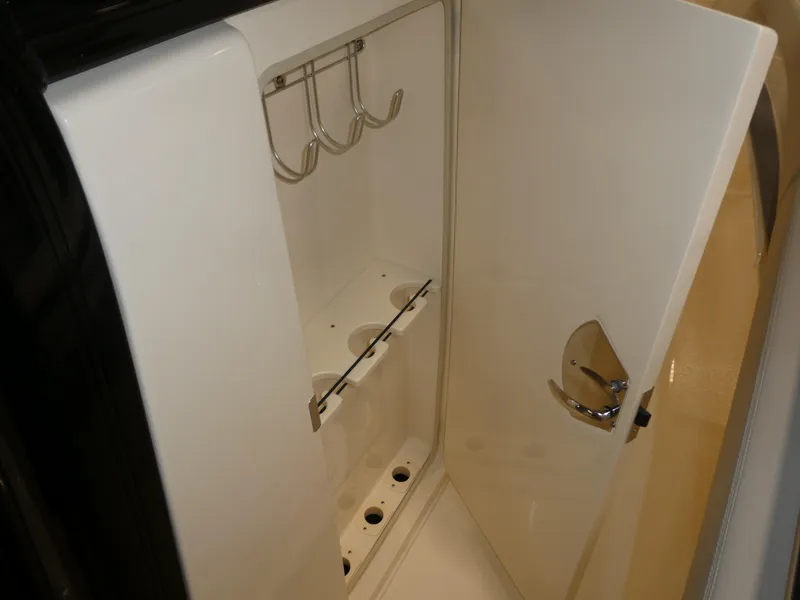 Slide: The Image of 2024 Scout 305 LXF boat storage compartment with hooks and holders. - 18