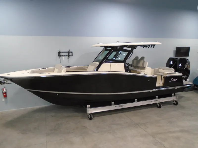 Slide: The Image of 2024 Scout 305 LXF boat in showroom, side view, black hull, modern design. - 2