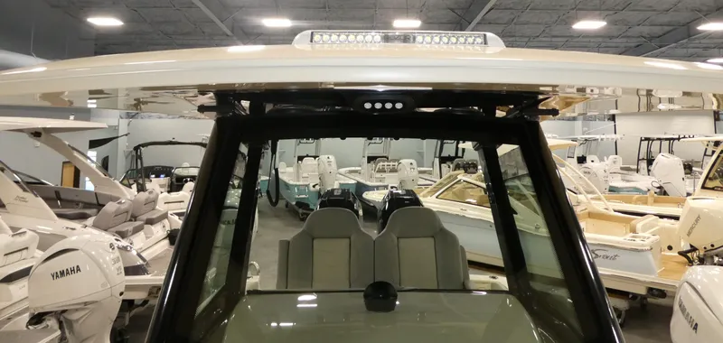 Slide: The Image of 2024 Scout 305 LXF boat interior with dual seats and Yamaha engines in showroom. - 24