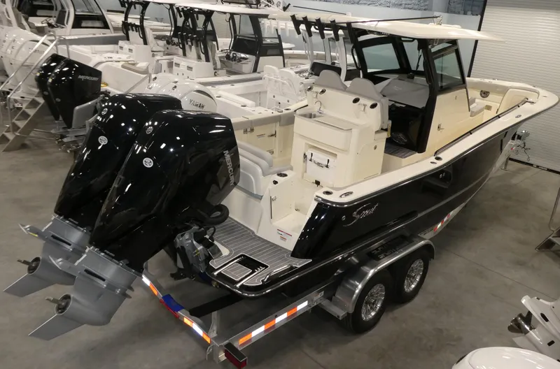 Slide: The Image of 2024 Scout 305 LXF boat with dual outboard engines on a trailer in a showroom. - 29