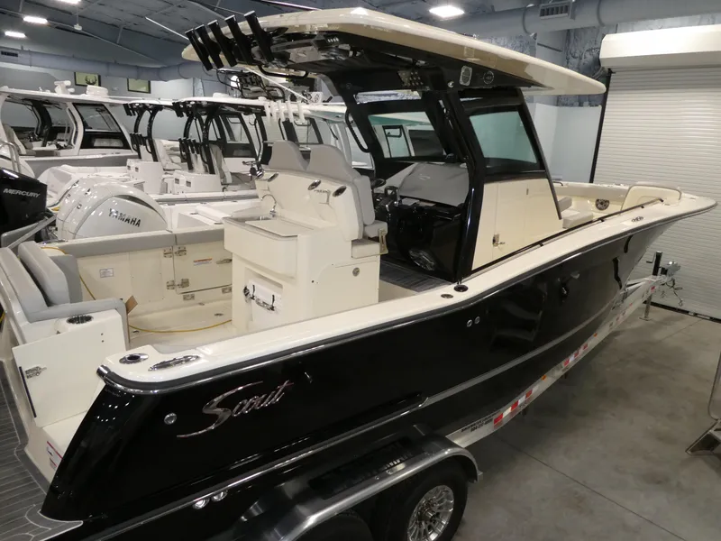 Slide: The Image of 2024 Scout 305 LXF boat in showroom, black hull, white interior, on trailer. - 30
