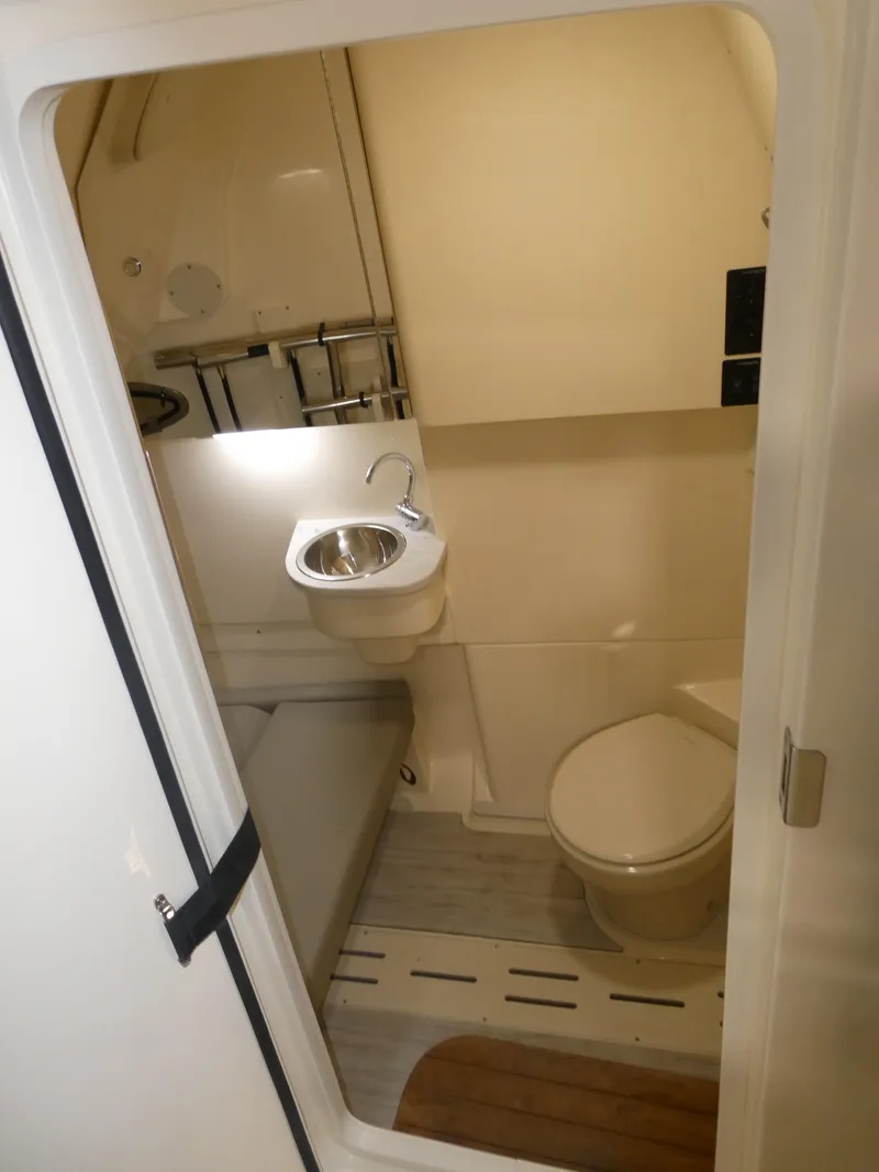 Slide: The Image of 2024 Scout 305 LXF boat interior bathroom with sink and toilet. - 41