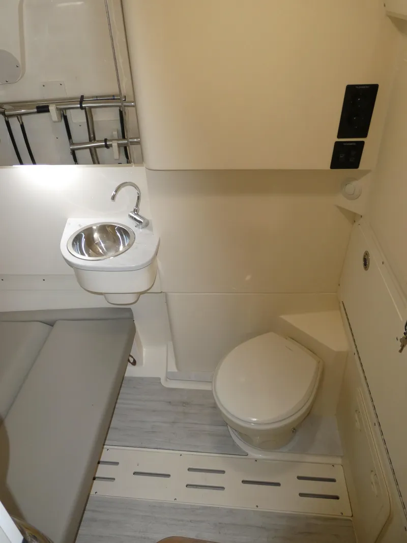 Slide: The Image of 2024 Scout 305 LXF boat interior bathroom with sink and toilet. - 42