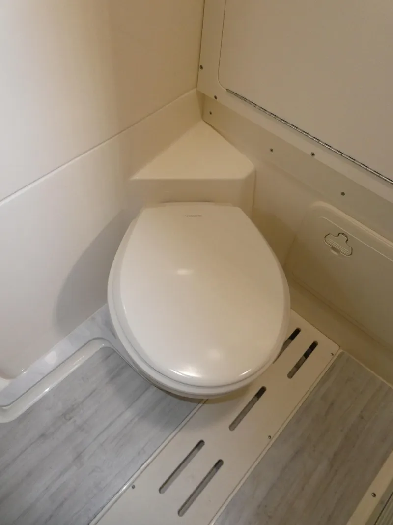 Slide: The Image of 2024 Scout 305 LXF boat bathroom with modern toilet and sleek design. - 44
