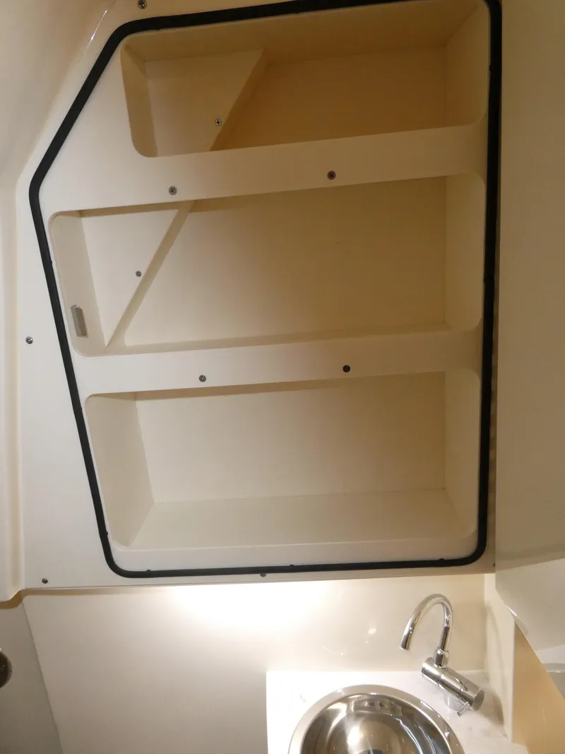 Slide: The Image of 2024 Scout 305 LXF boat interior storage compartments and sink. - 46