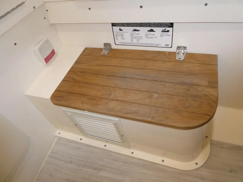 Slide: The Image of 2024 Scout 305 LXF boat interior with wooden seat and storage compartment. - 48