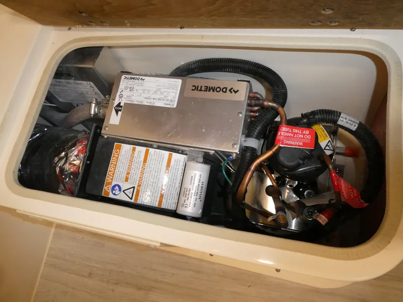 Slide: The Image of Electrical components inside a 2024 Scout 305 LXF boat compartment. - 49