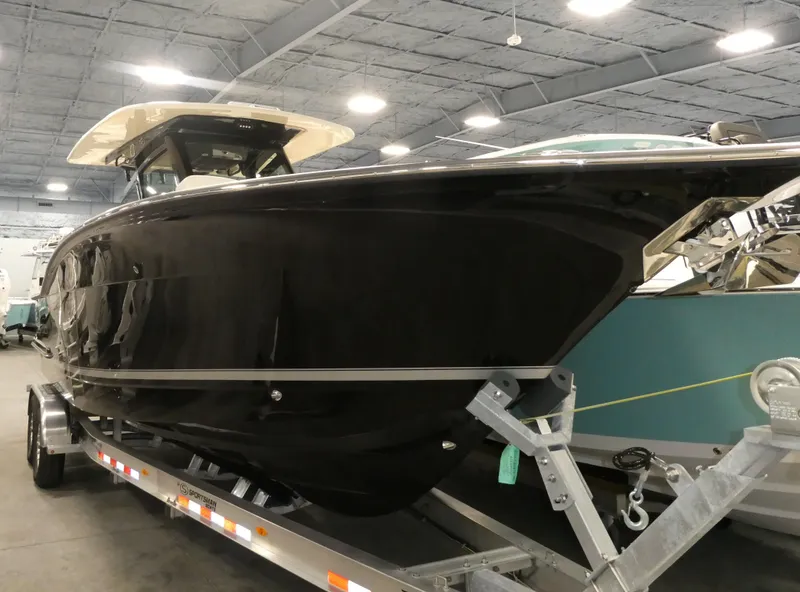 Slide: The Image of 2024 Scout 305 LXF boat on a trailer in an indoor showroom. - 6