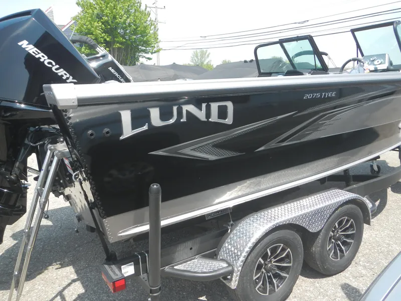 Slide: The Image of 2024 Lund 2075 Tyee boat on a trailer, featuring a sleek black exterior. - 1