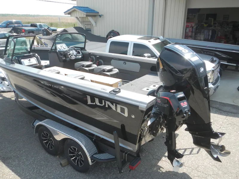 Slide: The Image of 2024 Lund 2075 Tyee boat on a trailer with a powerful outboard motor. - 2