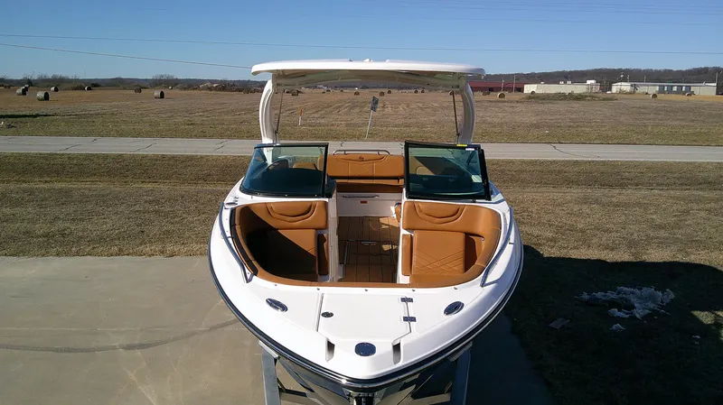 Slide: The Image of 2024 Chaparral 28 Surf boat with open bow seating, displayed outdoors. - 12