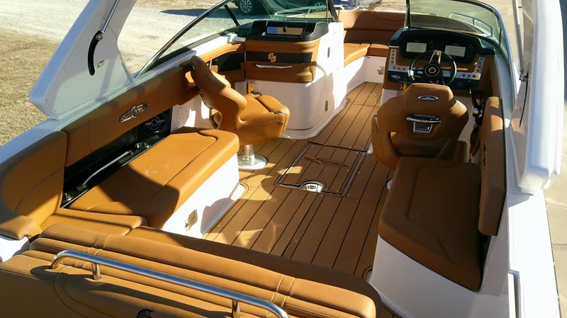 Slide: The Image of 2024 Chaparral 28 Surf boat interior with brown seating and sleek design. - 5