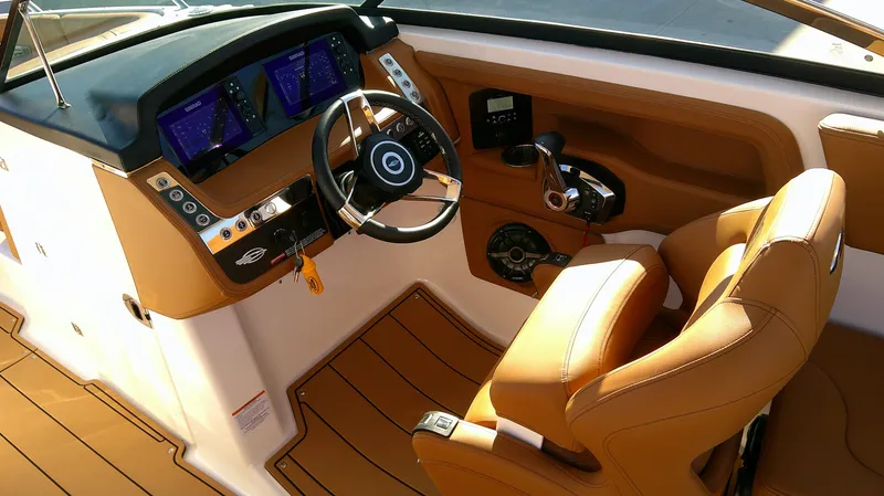Slide: The Image of 2024 Chaparral 28 Surf boat interior with modern dashboard and tan seating. - 6