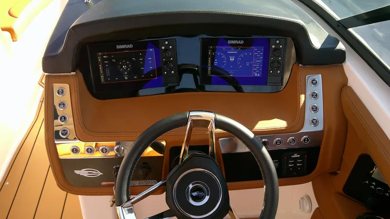 Slide: The Image of 2024 Chaparral 28 Surf boat dashboard with dual Simrad displays and modern controls. - 7