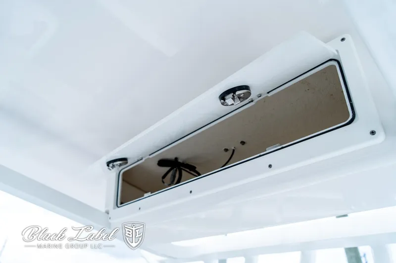 Slide: The Image of 2024 Sea Fox 231 Bay Fox Center Console storage compartment, open with visible wiring. - 24