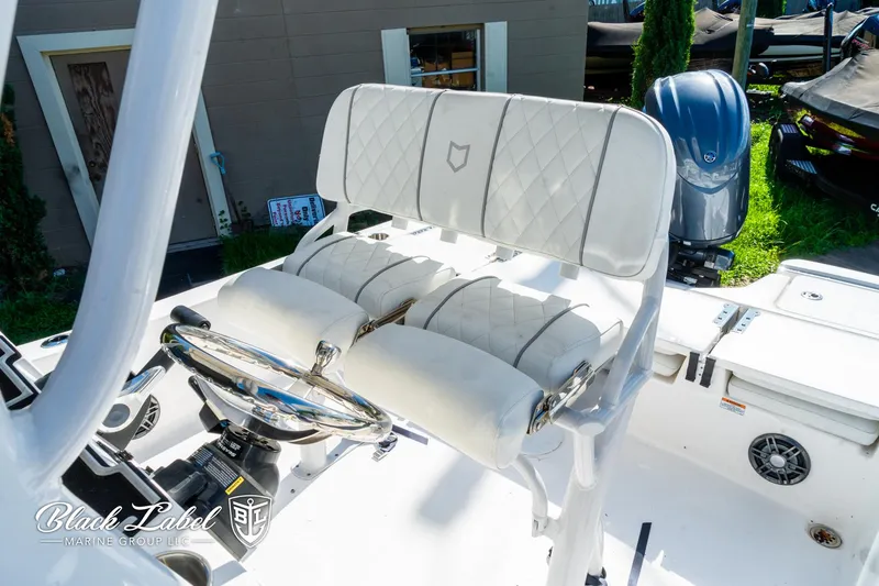 Slide: The Image of 2024 Sea Fox 231 Bay Fox Center Console with white cushioned seating and steering wheel. - 13