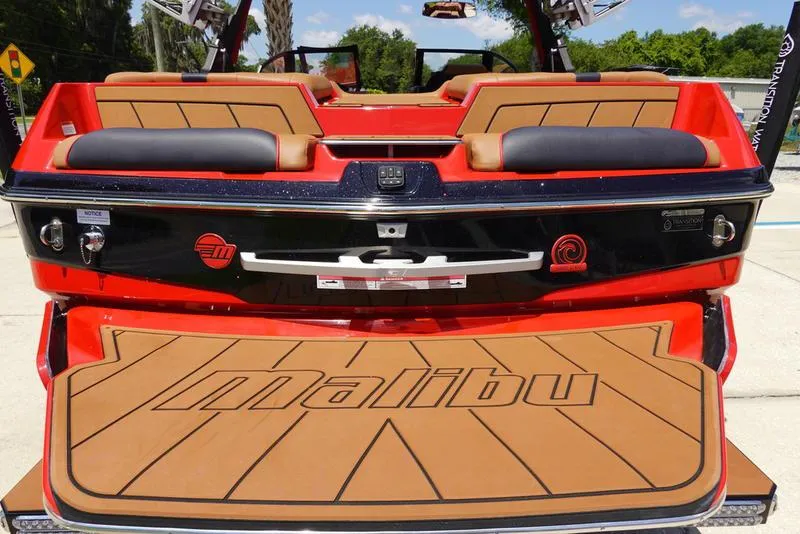 Slide: The Image of 2023 Malibu 23 LSV boat rear view with tan and black seating. - 10