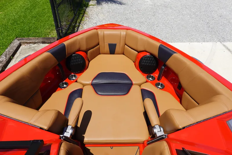 Slide: The Image of 2023 Malibu 23 LSV boat with tan and black cushioned seating. - 16