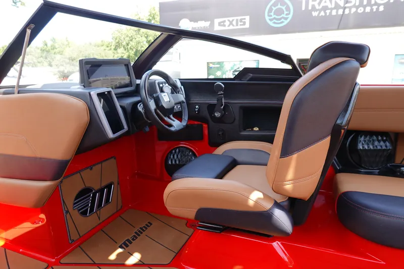 Slide: The Image of 2023 Malibu 23 LSV boat interior with red and tan seating, modern dashboard. - 20