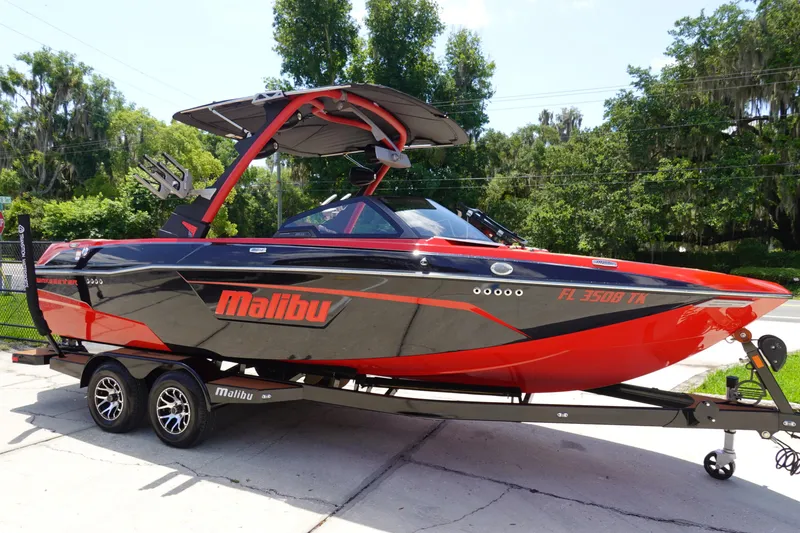 Slide: The Image of 2023 Malibu 23 LSV boat in red and black on a trailer. - 3