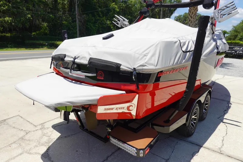 Slide: The Image of 2023 Malibu 23 LSV boat with cover, red and black, on trailer. - 30